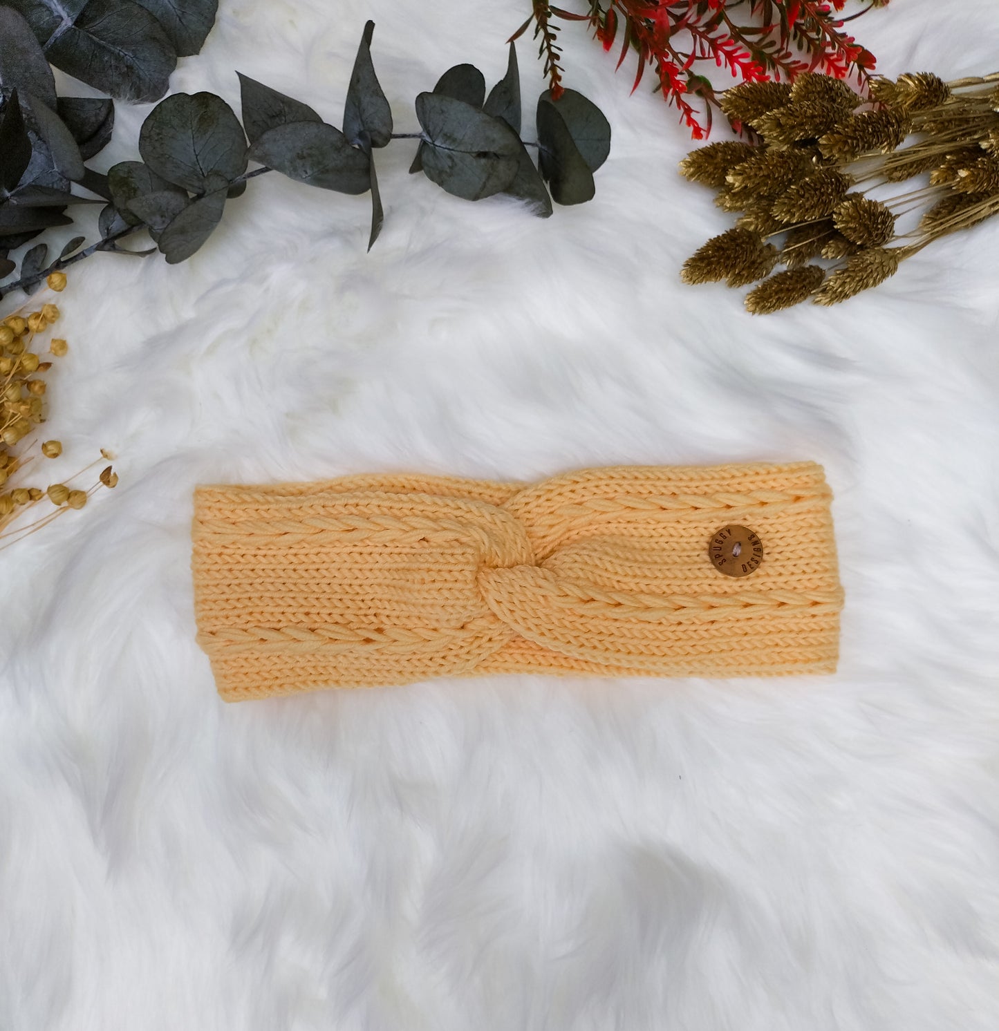 A buttercup yellow soft merino headbands, with a braided cable design. Handmade in the UK by sustainable knitwear brand Spuggy Designs. Perfect gift for teens, girlfriends, friends, sisters. Christmas gifts UK. Dopamine dressing.